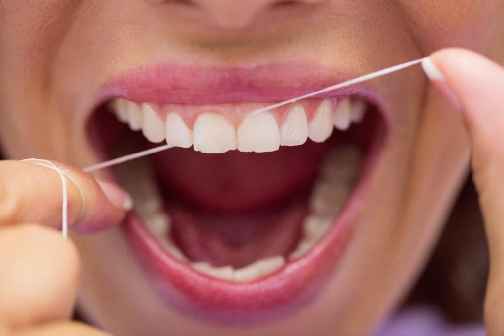 A person demonstrating Daily Flossing for Oral Health in Brentwood