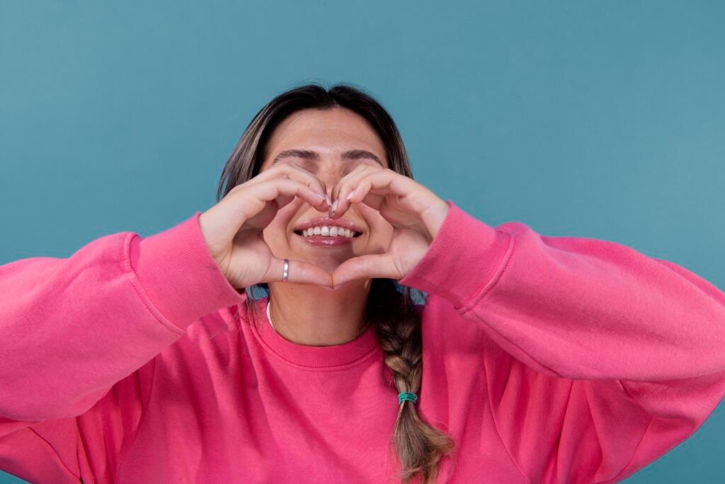 A Woman makes a heart shape symbolizing the connection between Gum Disease and Heart Health in Brentwood.